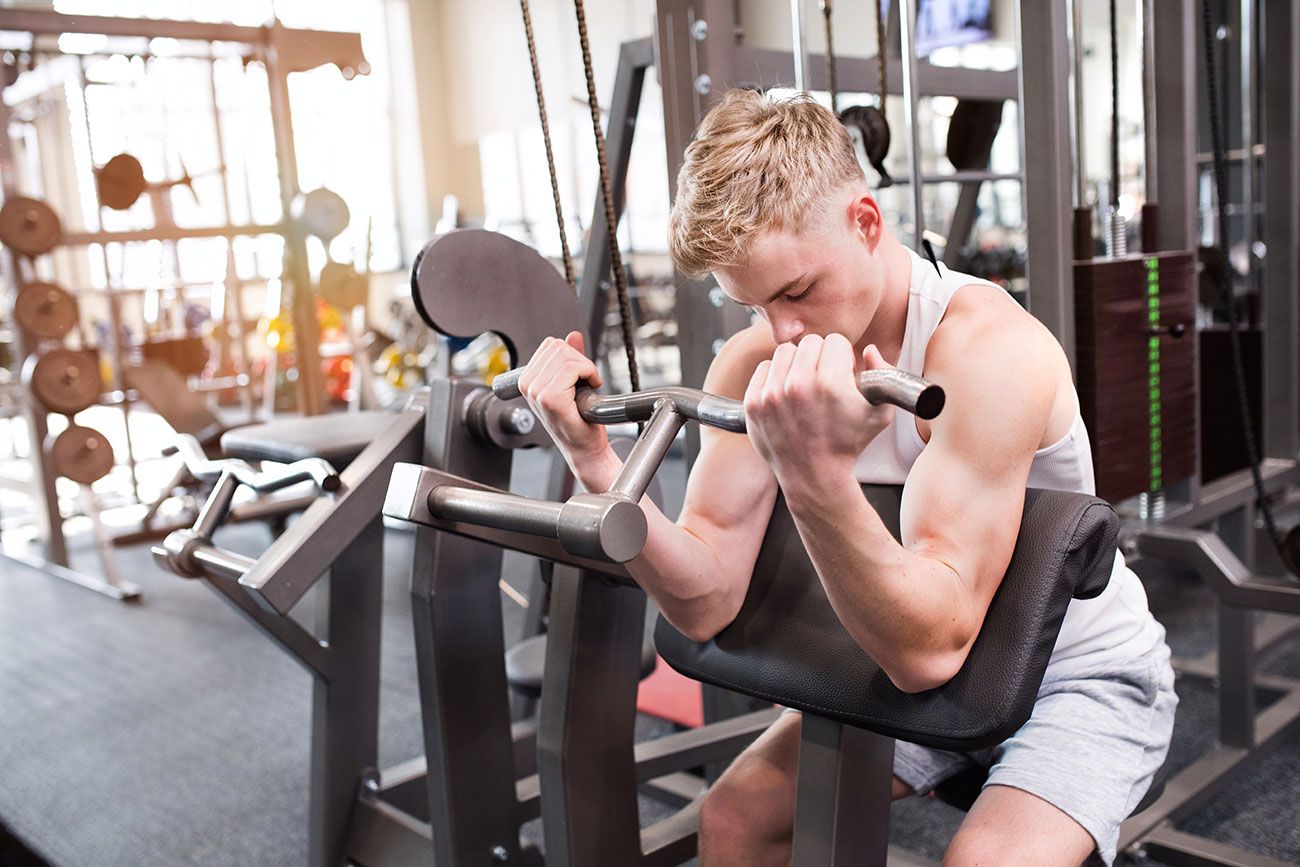 Ein junger Mann trainiert an einem Fitness-Gerät
